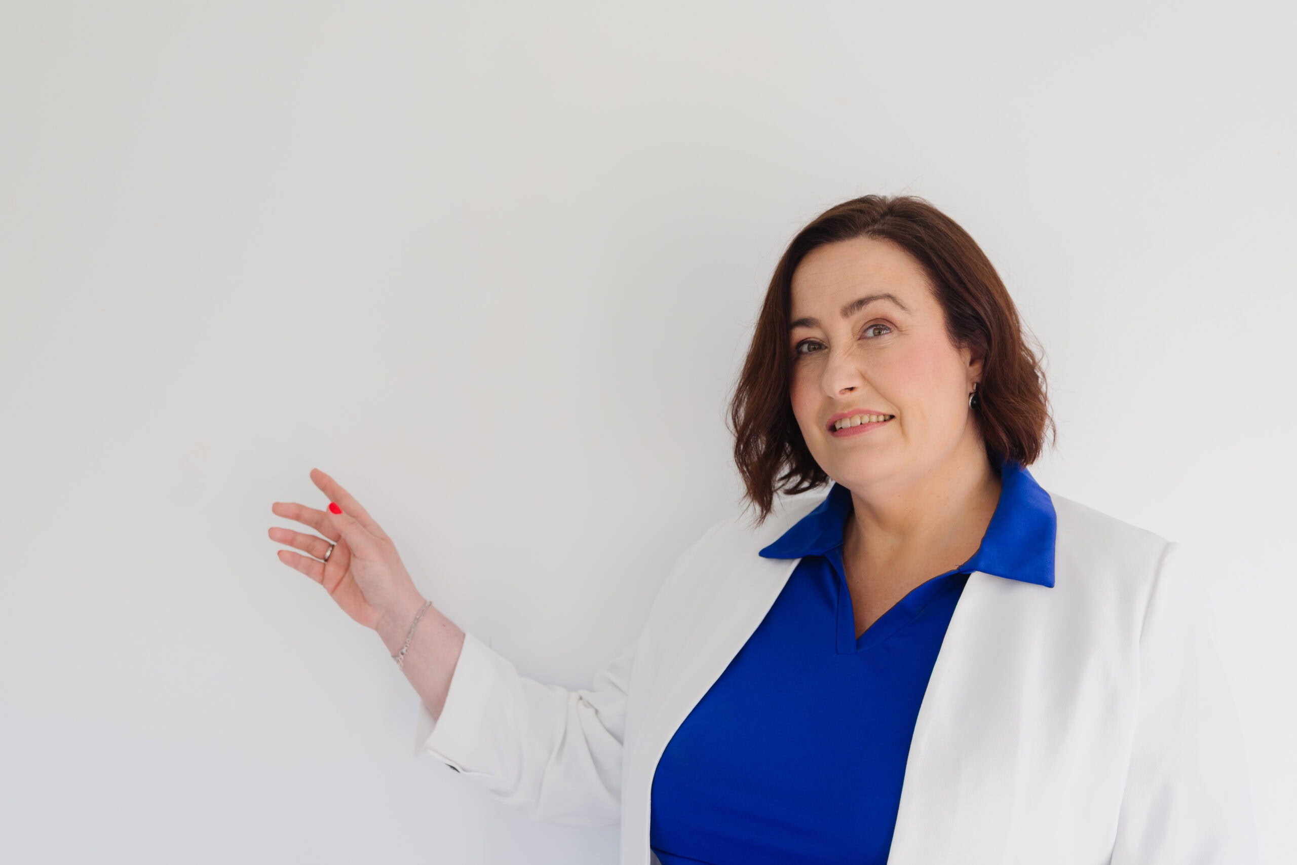 Professional woman in business attire presenting in a corporate setting.