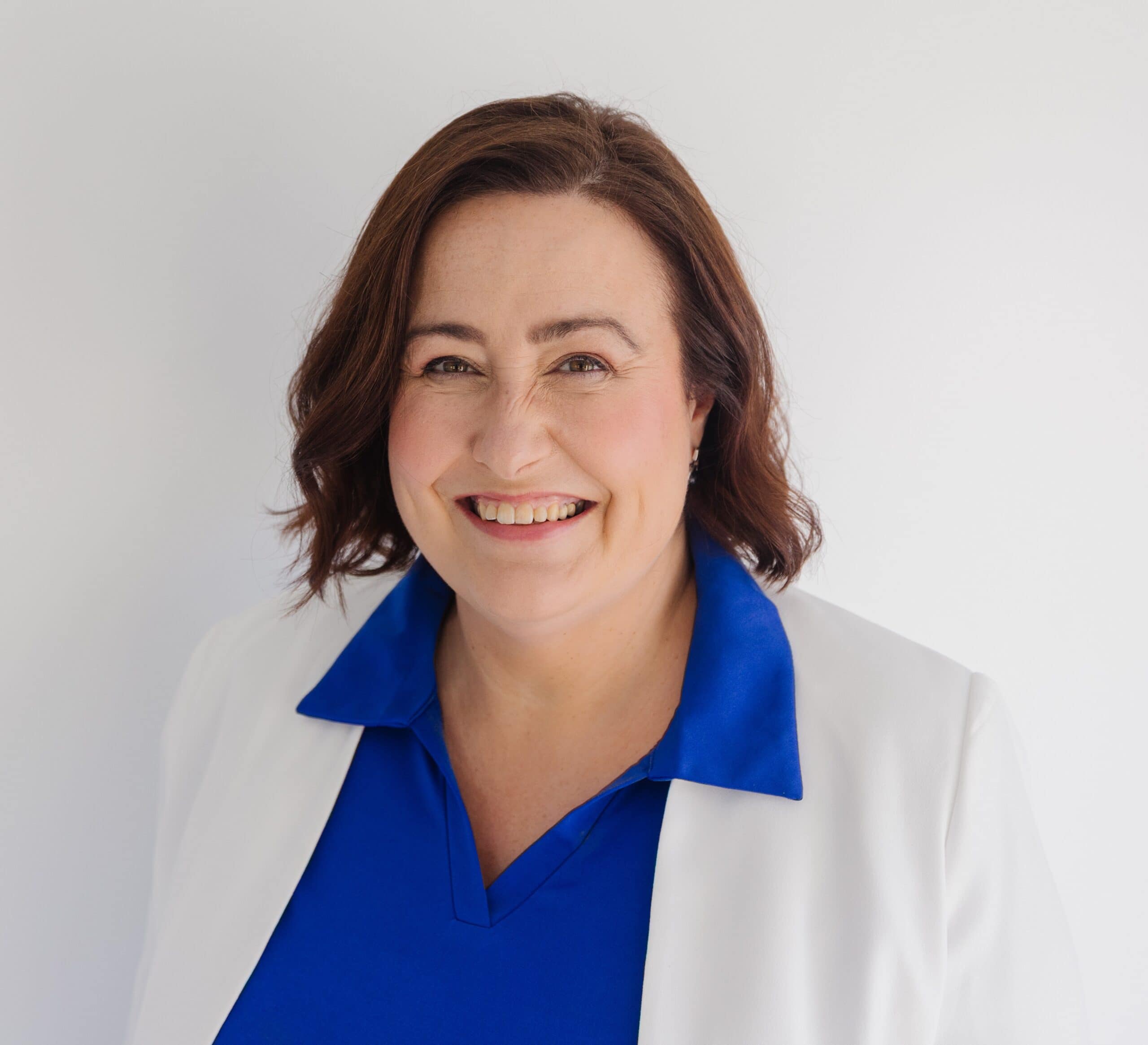 Businesswoman smiling in professional attire for SME system optimisation.