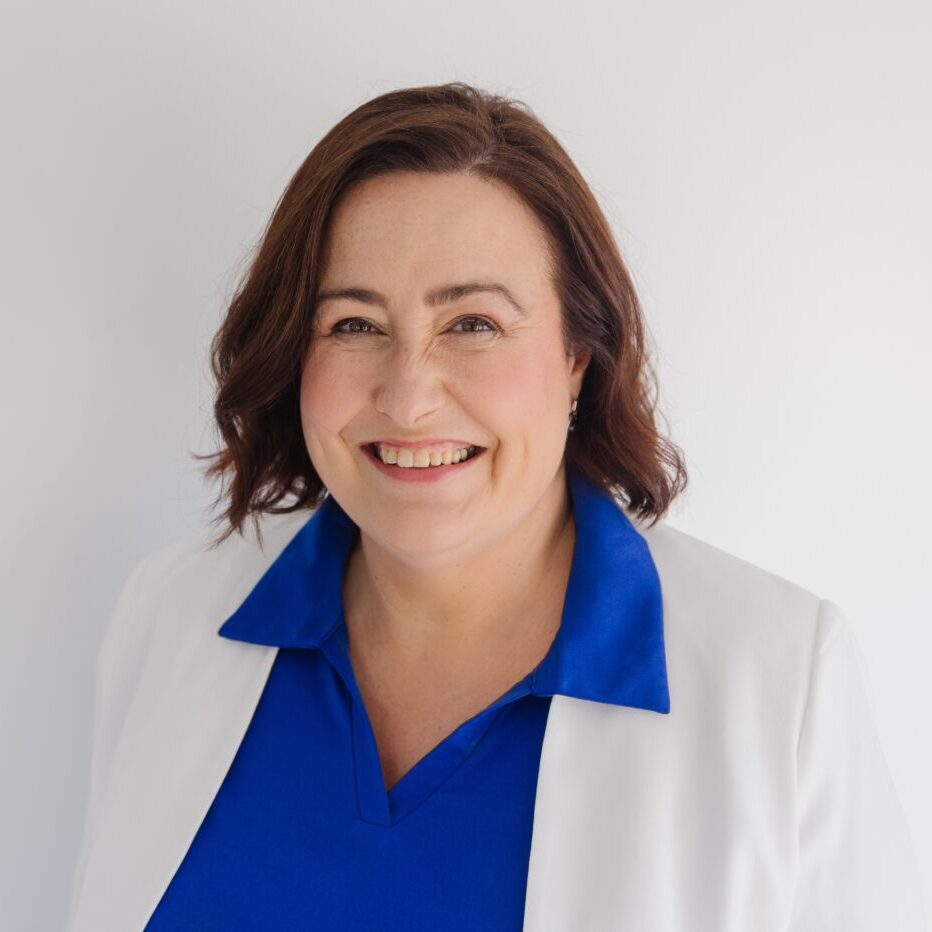 Businesswoman smiling in professional attire for SME system optimisation.